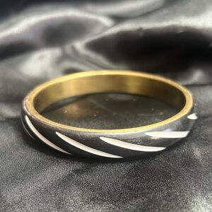 Gold tone bangle bracelet, colors of gold, black, and white